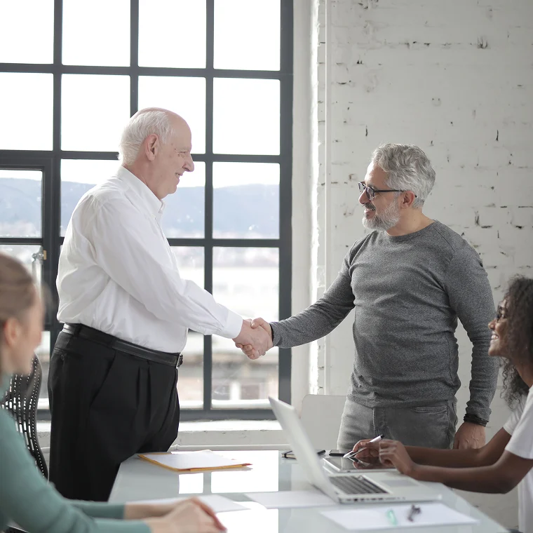 Two ministry leaders shaking hands across a conference table
