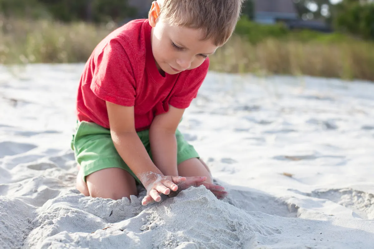 A young child playing in the sand